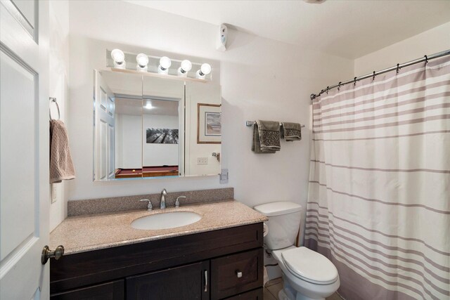 bathroom featuring toilet, curtained shower, and vanity