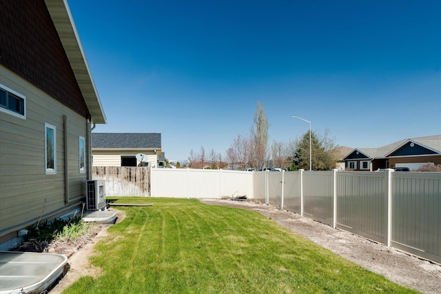 view of yard with a fenced backyard and ac unit
