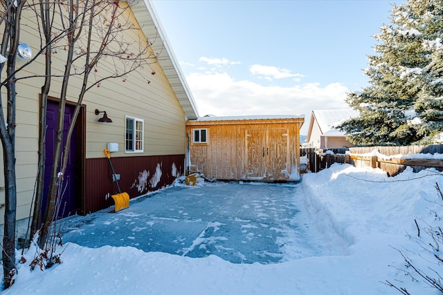 view of snow covered exterior featuring fence