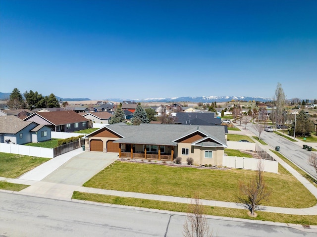 ranch-style house featuring an attached garage, fence, concrete driveway, a porch, and a residential view