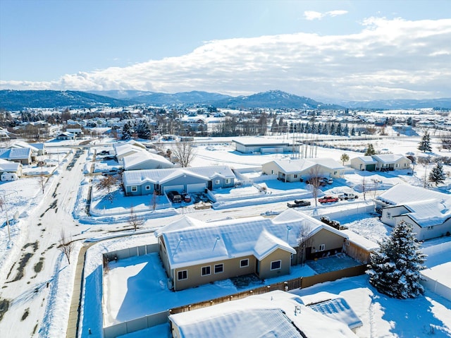 snowy aerial view featuring a residential view and a mountain view