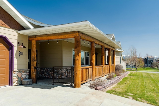 view of side of property with covered porch and a yard