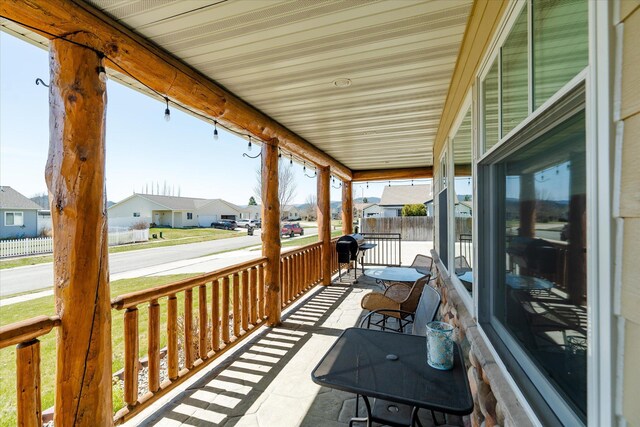 wooden terrace featuring a residential view and covered porch