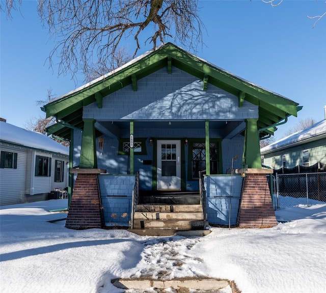 view of front of property featuring covered porch and fence