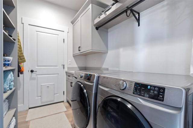laundry area featuring cabinet space, independent washer and dryer, and light wood-style floors