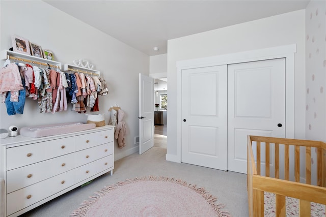 bedroom with light carpet, baseboards, and a closet