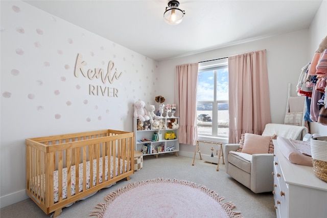 carpeted bedroom with baseboards, wallpapered walls, and a crib