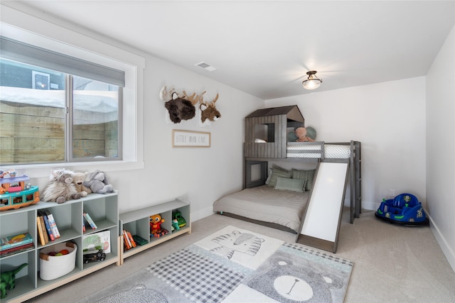 carpeted bedroom featuring baseboards and visible vents