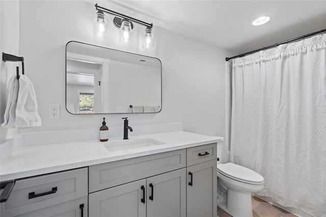full bath featuring toilet, a shower with curtain, vanity, and wood finished floors