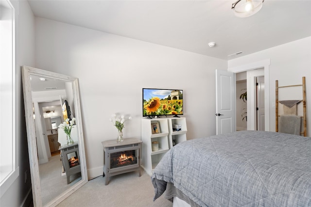 bedroom featuring a fireplace, light colored carpet, and visible vents