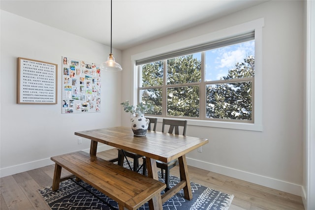 dining area featuring light wood finished floors and baseboards