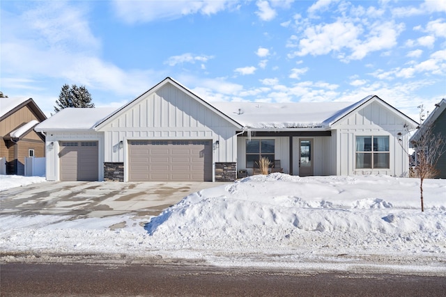 modern inspired farmhouse featuring board and batten siding, driveway, and an attached garage