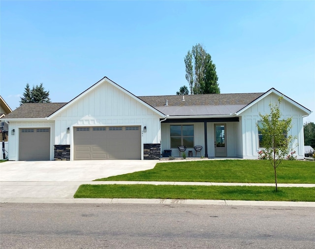 modern inspired farmhouse with driveway, an attached garage, board and batten siding, a front lawn, and a shingled roof