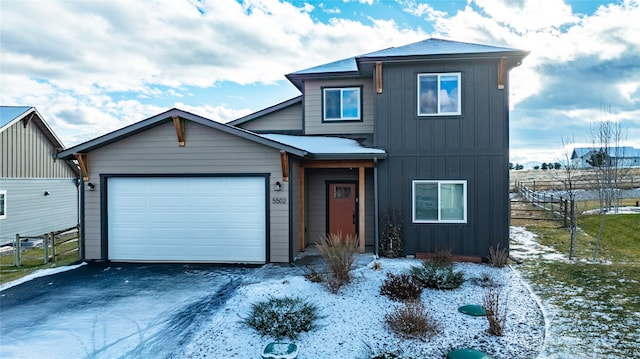 view of front facade featuring aphalt driveway, board and batten siding, an attached garage, and fence