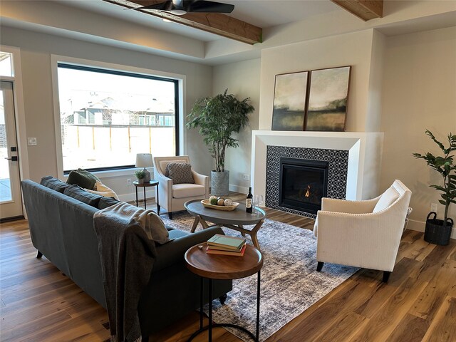 156 Antler Peak Ln, Kalispell, MT 59901 - living area featuring wood finished floors, healthy amount of natural light, a ceiling fan, beamed ceiling, and a tiled fireplace