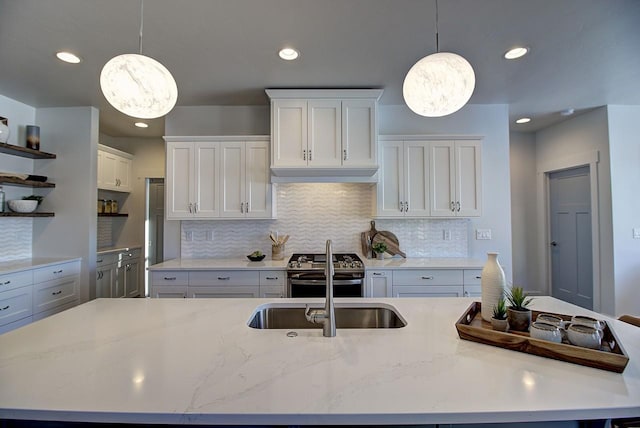 kitchen with hanging light fixtures, open shelves, stainless steel stove, and white cabinets