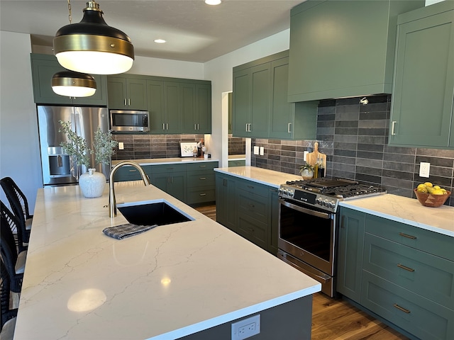 156 Antler Peak Ln, Kalispell, MT 59901 - kitchen featuring appliances with stainless steel finishes, green cabinets, light stone counters, backsplash, and recessed lighting