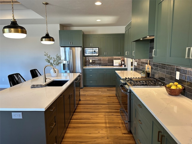 156 Antler Peak Ln, Kalispell, MT 59901 - kitchen featuring stainless steel appliances, wood finished floors, decorative backsplash, pendant lighting, and recessed lighting