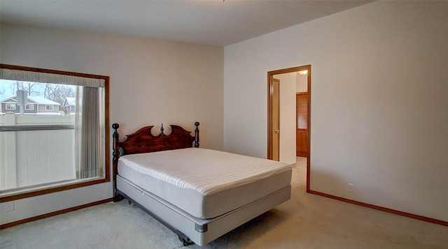 bedroom featuring light carpet and baseboards