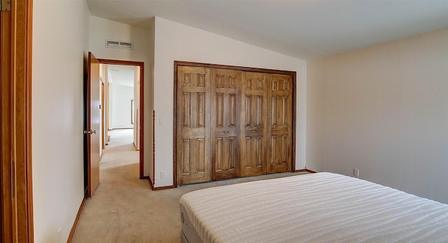 bedroom featuring light carpet, baseboards, visible vents, lofted ceiling, and a closet