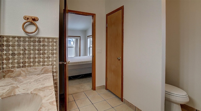 ensuite bathroom featuring ensuite bathroom, tile patterned flooring, and toilet