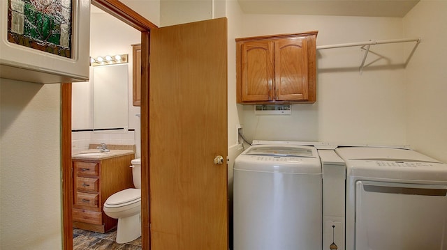 washroom with washer and dryer and a sink