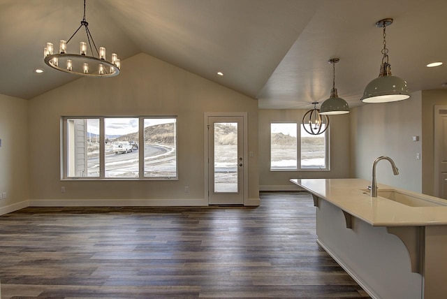 interior space featuring dark wood-type flooring, lofted ceiling, a sink, and baseboards