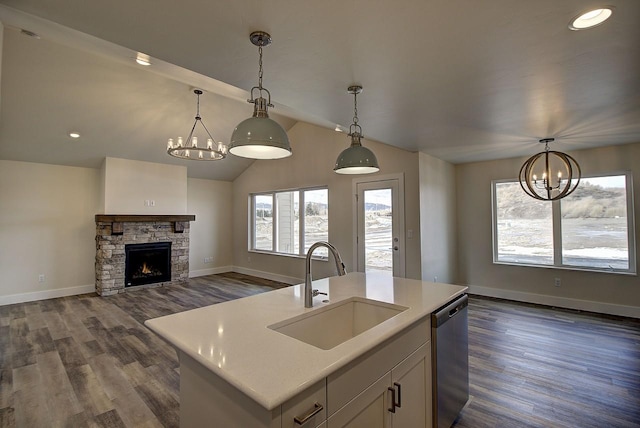 kitchen featuring open floor plan, stainless steel dishwasher, an island with sink, and pendant lighting