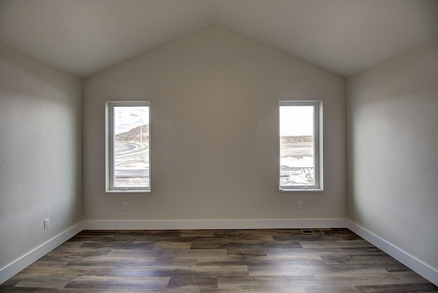 unfurnished room featuring lofted ceiling, baseboards, and dark wood-type flooring