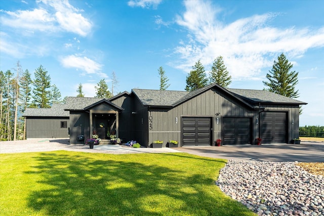 view of front of house with an attached garage, driveway, board and batten siding, and a front yard