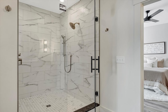 ensuite bathroom with connected bathroom, a ceiling fan, and a shower stall