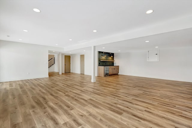 unfurnished living room featuring stairs, light wood-type flooring, and recessed lighting