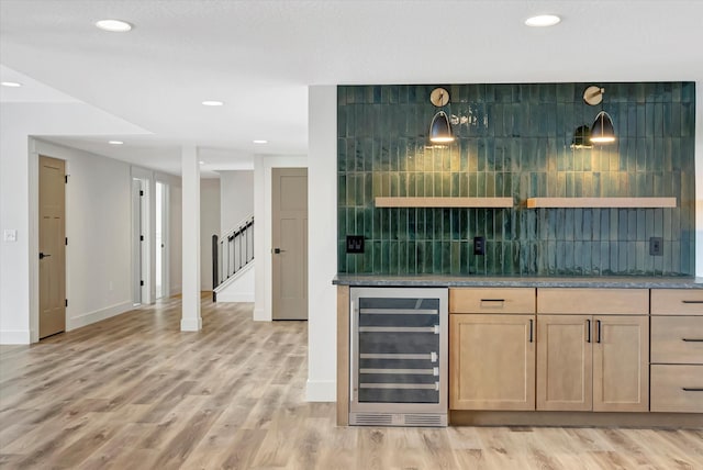 bar with pendant lighting, beverage cooler, light wood-style flooring, and decorative backsplash