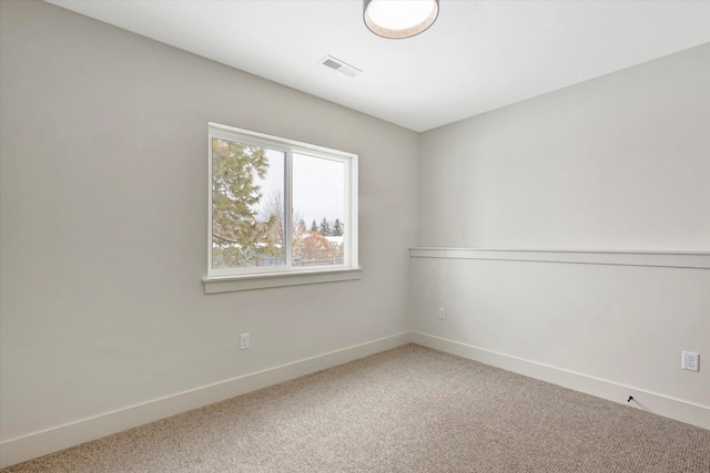 spare room with carpet, visible vents, and baseboards