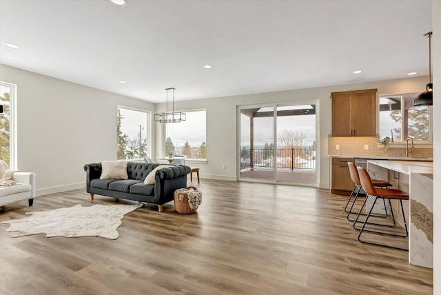 living area featuring a wealth of natural light, light wood-style flooring, baseboards, and recessed lighting