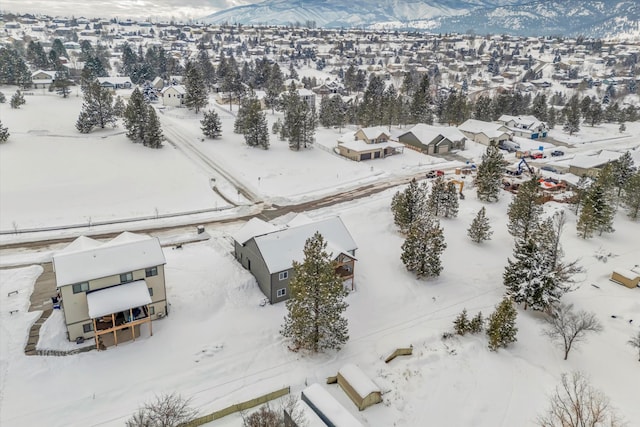 snowy aerial view featuring a residential view and a mountain view