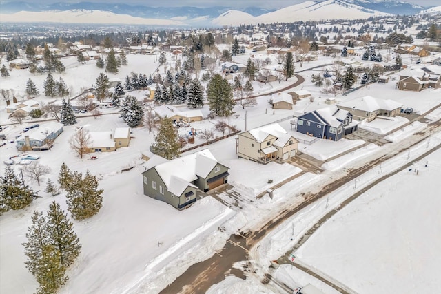 snowy aerial view with a residential view and a mountain view