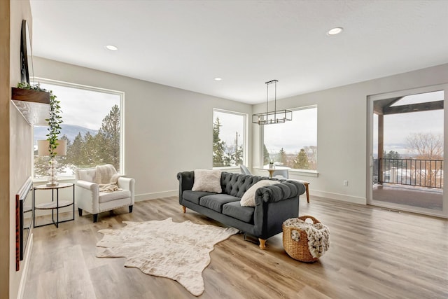 living area featuring a wealth of natural light, light wood-type flooring, baseboards, and recessed lighting