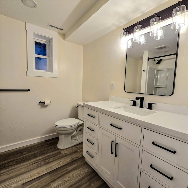 bathroom featuring visible vents, vanity, toilet, and wood finished floors