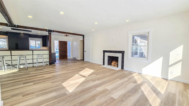 unfurnished living room with light wood-type flooring, a brick fireplace, and recessed lighting