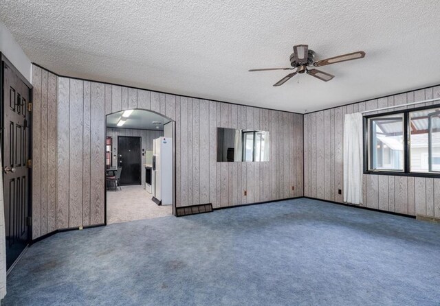3501 1st Ave S, Great Falls, MT 59401 - spare room with ceiling fan, arched walkways, carpet flooring, a textured ceiling, and wooden walls