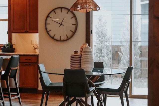 dining area featuring a wall of windows and wood finished floors