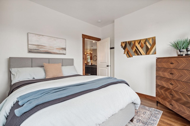 bedroom with baseboards and wood finished floors