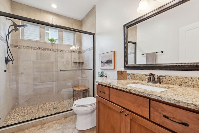 full bath with a stall shower, vanity, and toilet