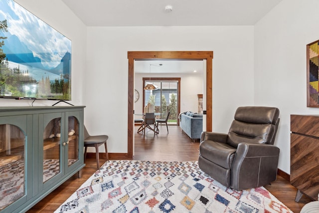 living area with dark wood-type flooring and baseboards