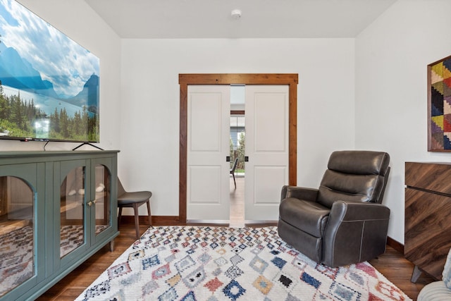 sitting room with dark wood-style flooring and baseboards