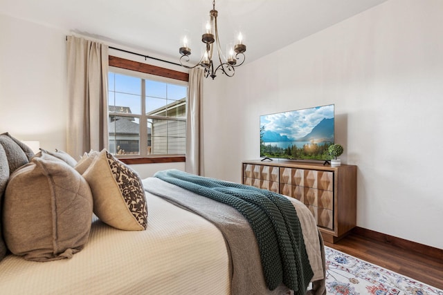 bedroom with a chandelier, dark wood-style flooring, and baseboards