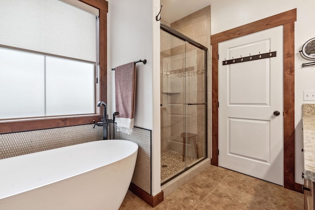 full bathroom featuring a freestanding bath, a shower stall, and tile patterned floors