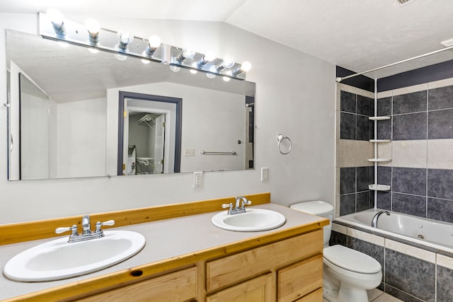 bathroom with toilet, double vanity, vaulted ceiling, and a sink