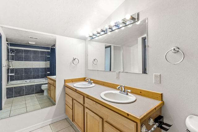 full bathroom with toilet, tile patterned flooring, a sink, and tiled shower / bath combo